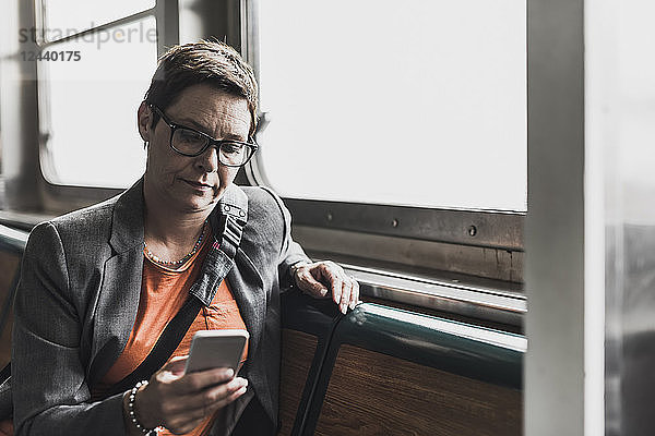 Businesswoman on a ferry looking on cell phone