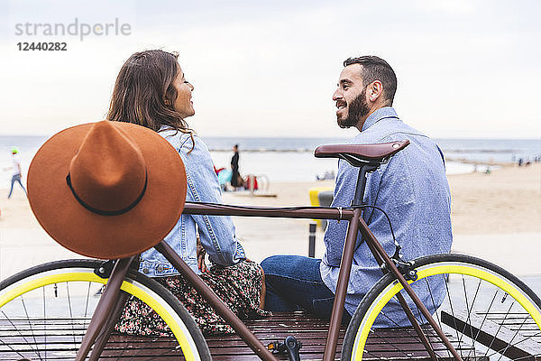 Spain  Barcelona  couple with bicycle sitting at the seaside