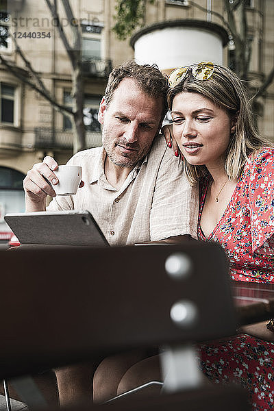 Couple looking at tablet at an outdoor cafe