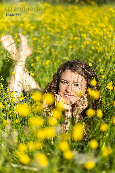 Young woman lying on flower meadow