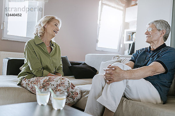 Senior couple at home talking on couch