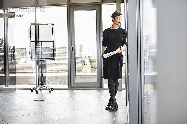 Businesswoman standing in office looking out of window