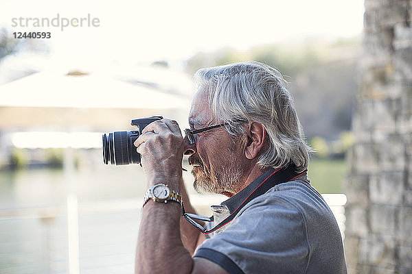 Senior man taking picture with his camera