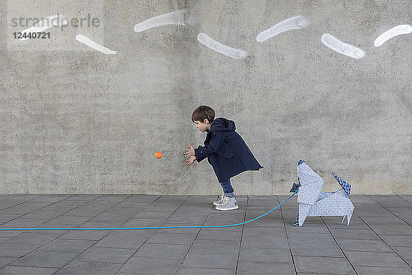 Little boy playing with ball  origami dog