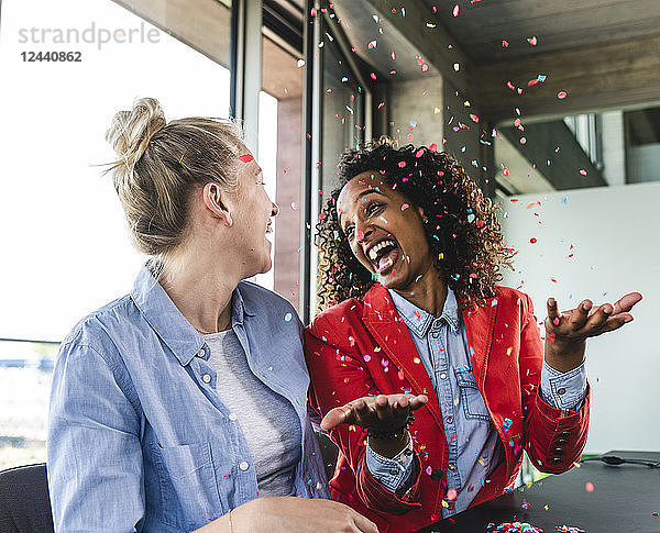 Young busniesswomen celebrating success  throwing confetti