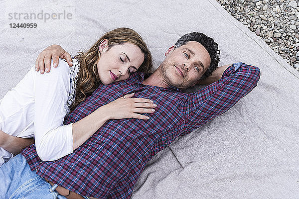 Affectionate couple lying on a blanket