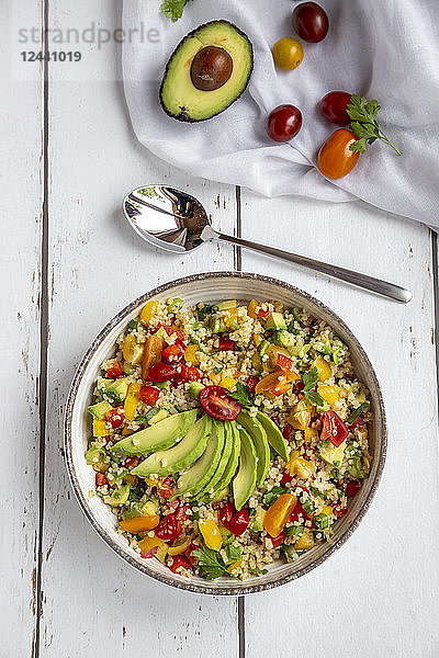 Bowl of bulgur salad with bell pepper  tomatoes  avocado  spring onion and parsley