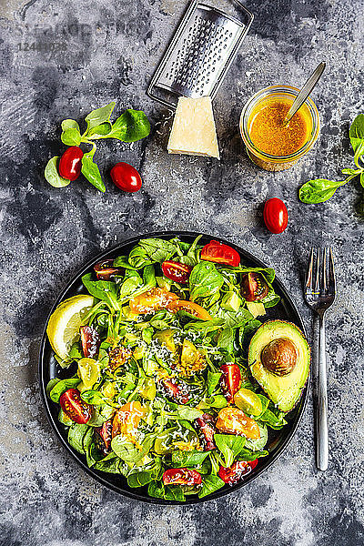 Salad with lamb's lettuce  tomatoes  avocado  parmesan and curcuma lemon dressing