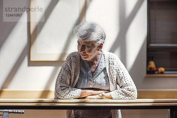 Lonely senior woman leaning on railing  looking down