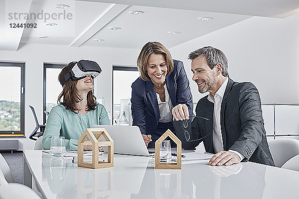 Business people having a meeting in office with VR glasses  laptop and architectural models