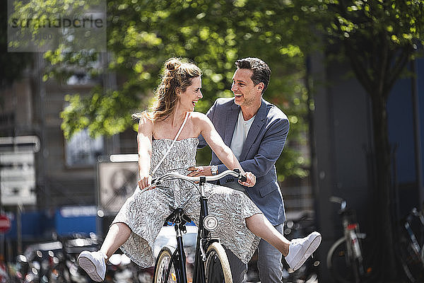 Happy carefree couple with bicycle in the city