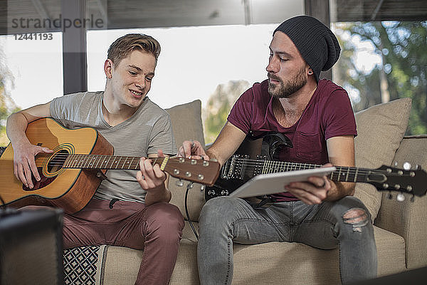 Musician teaching student how to play guitar