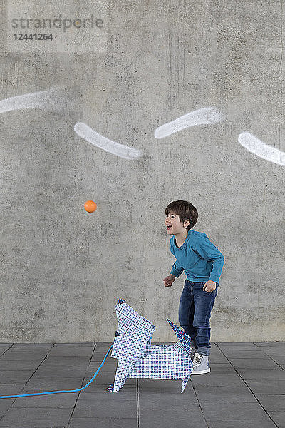 Little boy playing with ball  origami dog