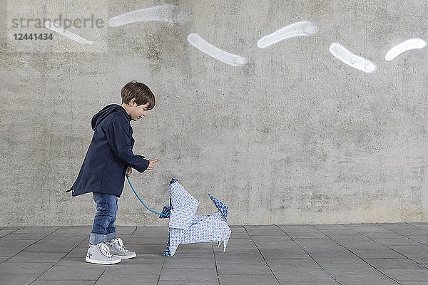 Little boy exercising with origami dog