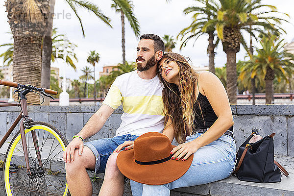 Spain  Barcelona  affectionate couple sitting on bench relaxing