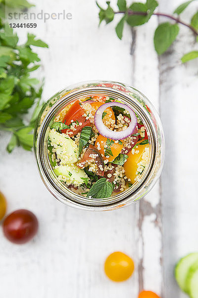 Preserving jar of Couscous salad with tomatoes  cucumber  parsley and mint