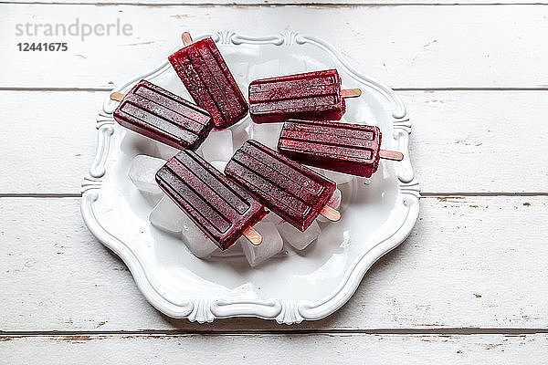 Cherry ice lollies on ice cubes and plate