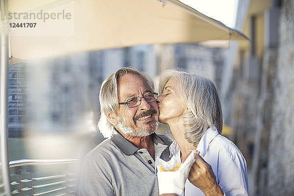 Senior couple taking a city break  eating French fries