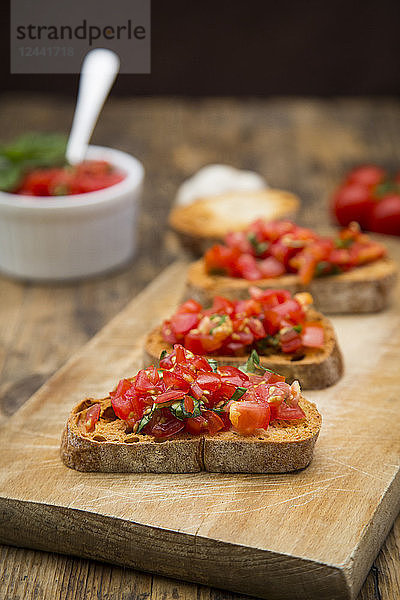 Bruschetta with tomato and basil on wooden board  close up