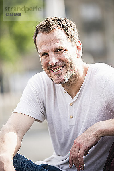 Portrait of smiling man sitting outdoors