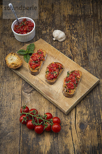 Bruschetta with tomato and basil on wooden board