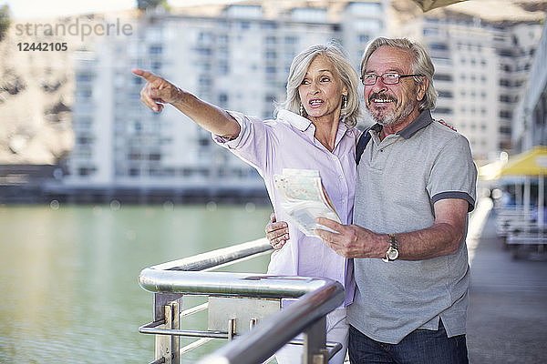 Senior couple taking a city break  holding map