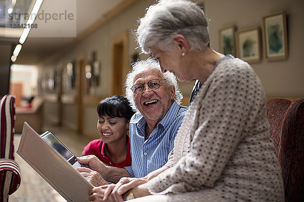 Nurse teaching seniors in retirement home  how to use laptop