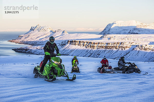 Motorschlittenfahrer haben Spaß in den Bergen um Djupavik; Djupavik  Westfjorde; Island