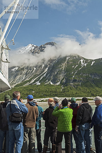 Touristen betrachten die Landschaft vom Deck des Tagesausflugsbootes Baranof Wind der Berge auf der Ostseite der Glacier Bay hinter Russell Island  Glacier Bay National Park  Südost-Alaska; Alaska  Vereinigte Staaten von Amerika
