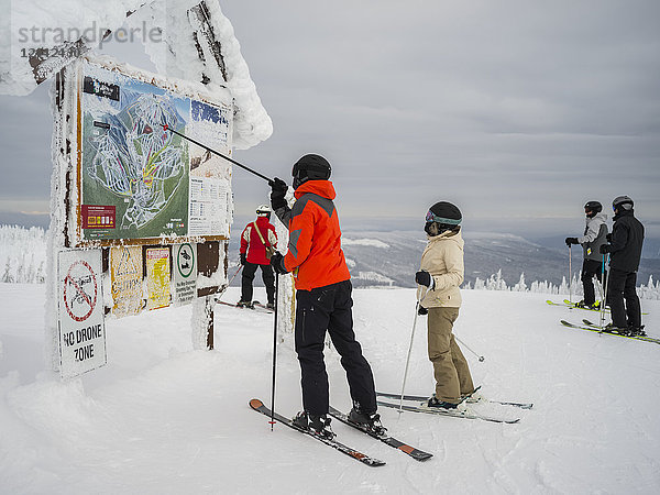 Skifahrer sehen sich eine Karte im Sun Peaks Skigebiet an; Kamloops  British Columbia  Kanada