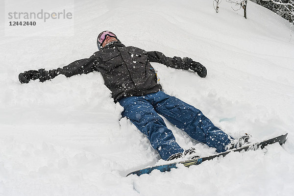 Snowboarder im Schnee liegend im Sun Peaks Resort; Kamloops  British Columbia  Kanada