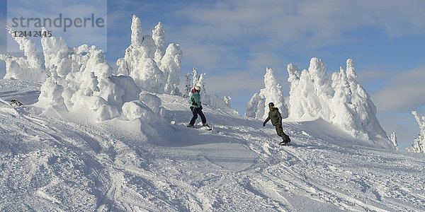 Snowboarden auf einer Piste im Skigebiet Sun Peaks mit Schneegeistern auf dem Gipfel des Berges; Kamloops  British Columbia  Kanada