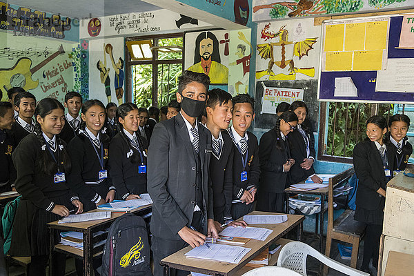 Ein Klassenzimmer mit jugendlichen Schülern in Uniform  einer von ihnen trägt eine Maske über dem Mund; Sikkim  Indien