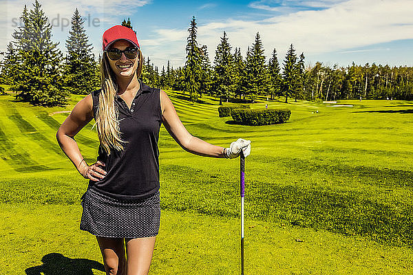 Porträt einer Golferin  die mit ihrem Driver auf dem grünen Rasen eines Golfclubs steht; Edmonton  Alberta  Kanada