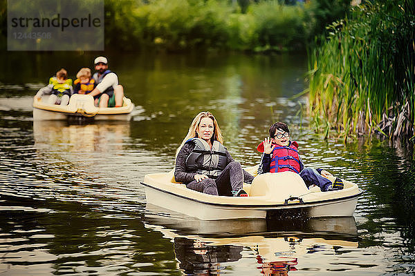 Eine Mutter und ein Vater fahren mit ihren drei Söhnen auf einem See in einem Stadtpark Paddelboot  Edmonton  Alberta  Kanada
