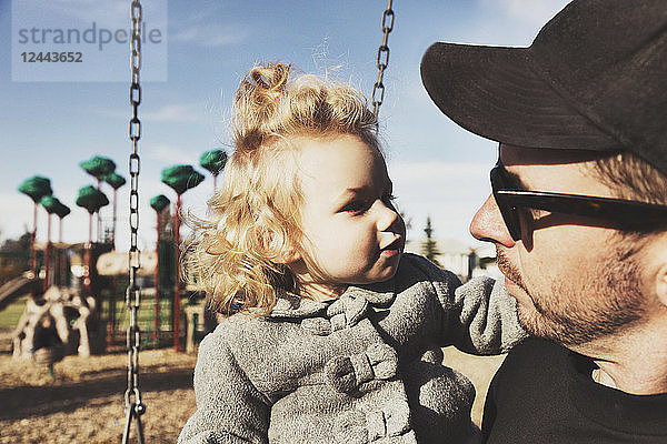 Ein süßes kleines Mädchen mit ihrem Vater nach dem Spielen auf einem Spielplatz während der Herbstsaison  Spruce Grove  Alberta  Kanada