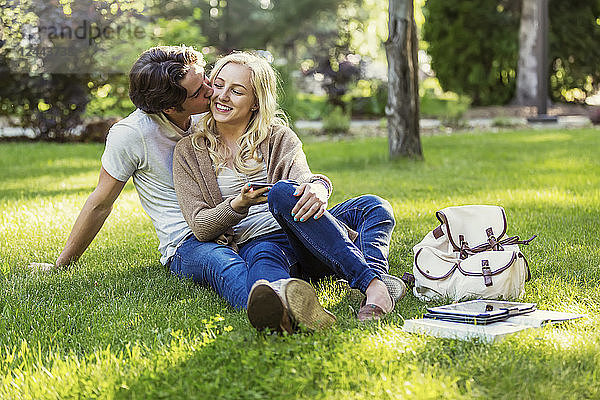 Ein junges Paar genießt einen romantischen Moment im Gras auf dem Universitätscampus  Edmonton  Alberta  Kanada