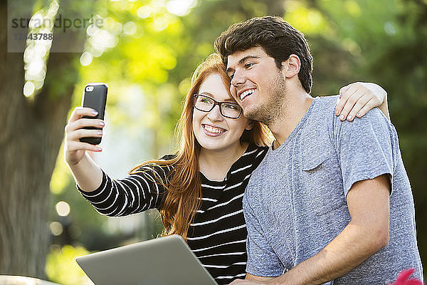 Ein junger Mann und eine junge Frau machen ein Selbstporträt mit einem Smartphone  Edmonton  Alberta  Kanada