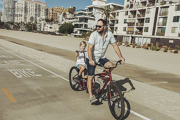 Ein Vater und seine Tochter fahren auf einem Tandem in Long Beach; Long Beach  Kalifornien  Vereinigte Staaten von Amerika
