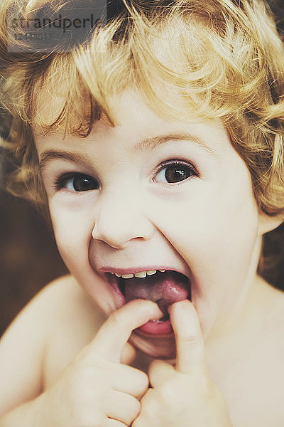 Kleinkind macht lustige Gesichter vor der Kamera und steckt sich die Finger in den Mund; Langley  British Columbia  Kanada