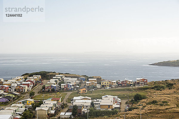 Kleines Fischerdorf mit bunten Häusern  von oben gesehen mit dem Meer in der Ferne; Ancud  Insel Chiloe  Chile