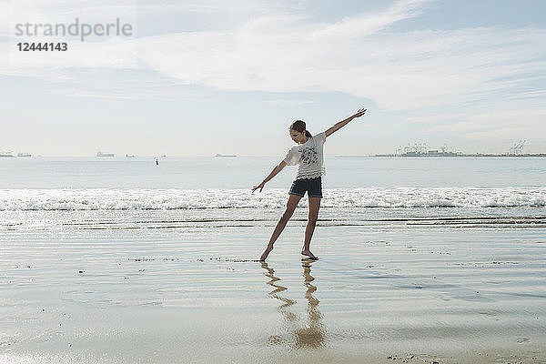 Ein Mädchen in einer Tanzpose am Strand; Long Beach  Kalifornien  Vereinigte Staaten von Amerika