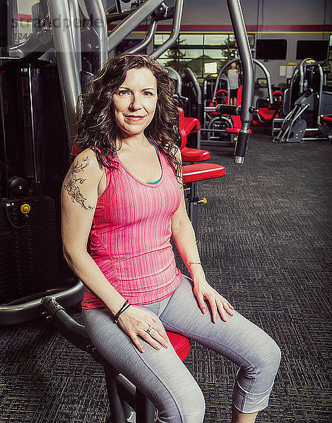 Eine Frau mittleren Alters  die in einem Fitnessstudio trainiert und dabei für die Kamera posiert  Spruce Grove  Alberta  Kanada