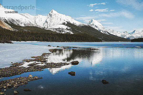Auftauen eines zugefrorenen Sees und schneebedeckte  schroffe Berggipfel  Jasper National Park; Alberta  Kanada