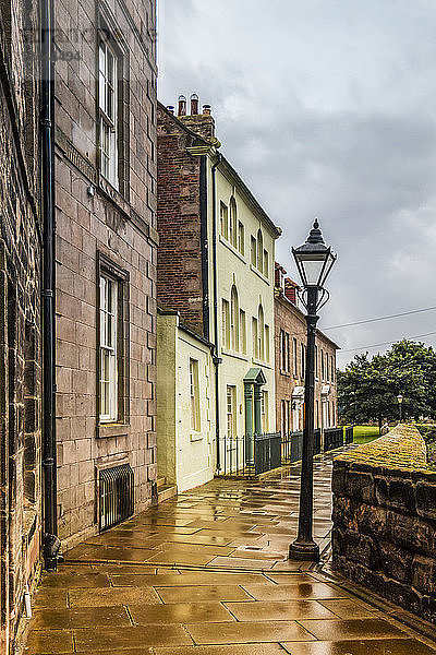 Straße mit georgianischen Häusern und Laternenpfahl mit regennassem Pflaster  Berwick Upon Tweed  England