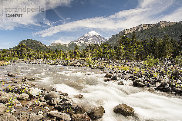 Ein Bergfluss mit einem schneebedeckten Vulkan in der Ferne; Neuquen  Argentinien