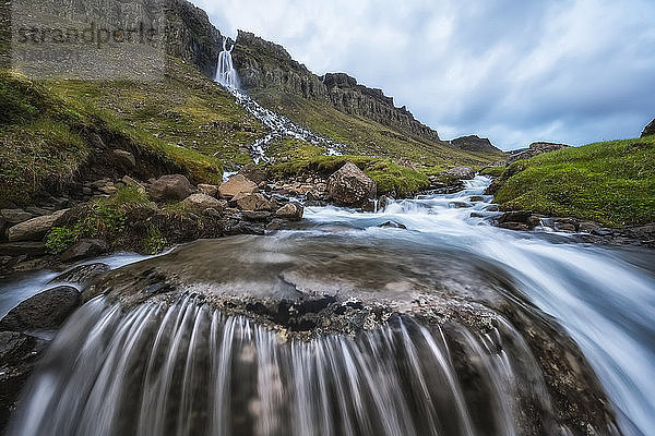 Bewegungsunschärfe von fließendem Wasser an einem Wasserfall bei Djupavik  Westfjorde  Island