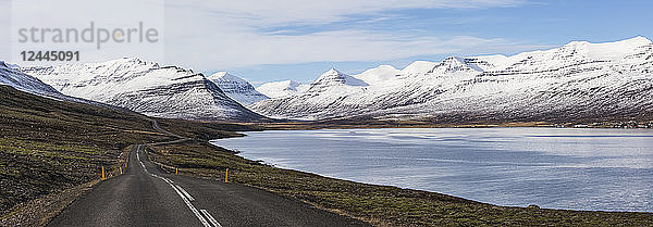 Die Straße entlang eines Fjords in der isländischen Ostfjordregion  die in die Berge führt  Island