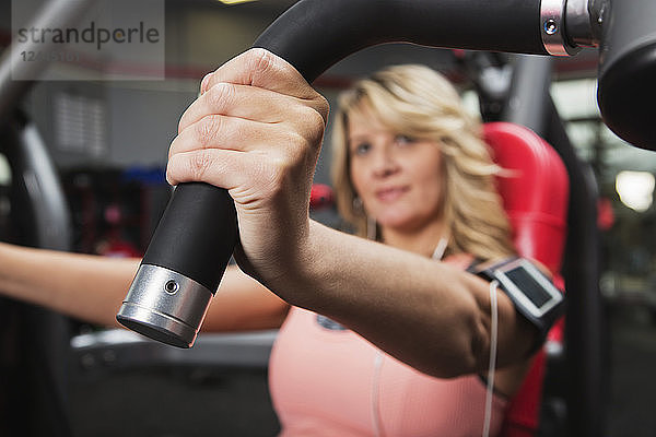 Eine Frau mittleren Alters beim Oberkörpertraining in einem Fitnessstudio  Spruce Grove  Alberta  Kanada