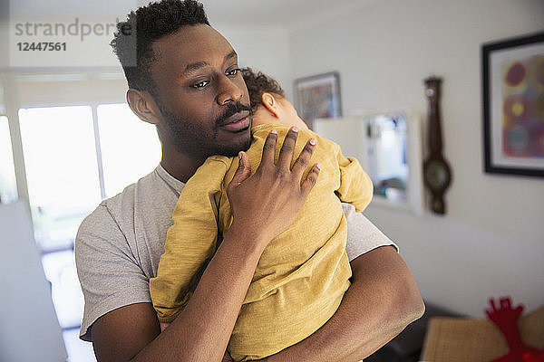 Zärtlicher Vater hält müden Babysohn